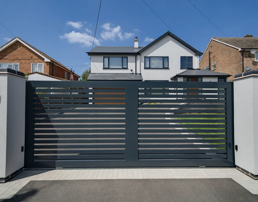 Modern horizontal-slat aluminium driveway gate in front of a contemporary home, Cookhill
