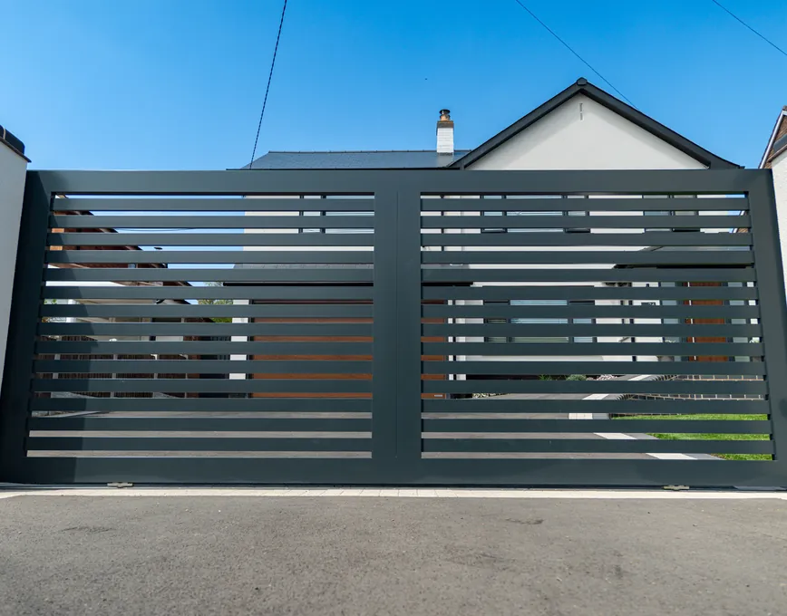 Bespoke anthracite aluminium slatted driveway gate between white rendered piers, made by Capitan in Cookhill, Worcestershire