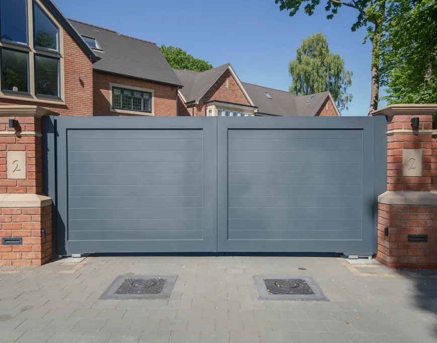 Automated grey aluminium driveway gates between red brick piers, Solihull