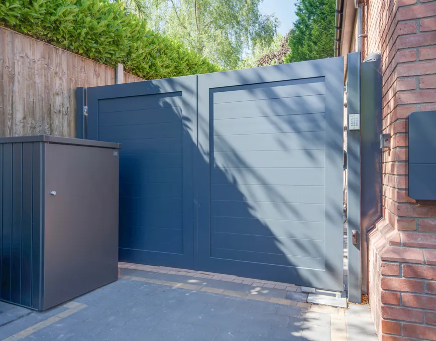 Solid grey aluminium privacy gates at the side of a brick house, Solihull