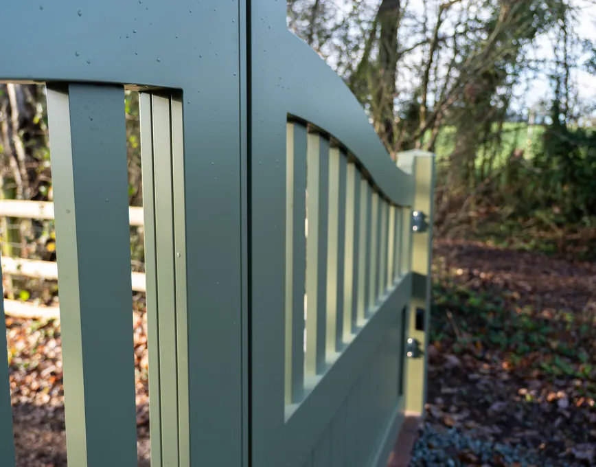 Close-up of a sage green gate's spindle top