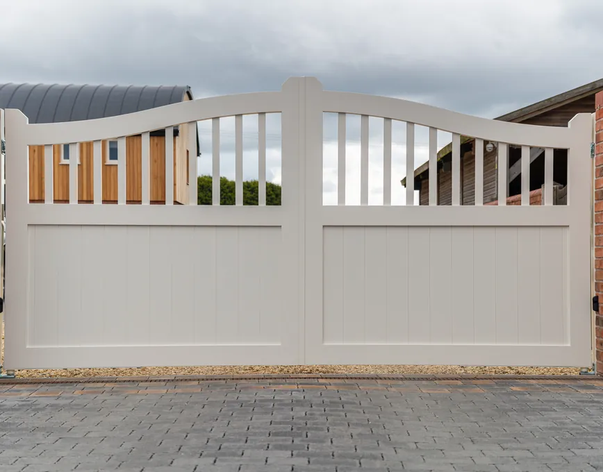 Cream automated swing gates between brick piers, near Bromsgrove