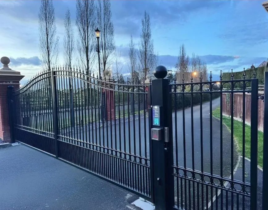 Traditional black steel swing gates with arched railings and finials