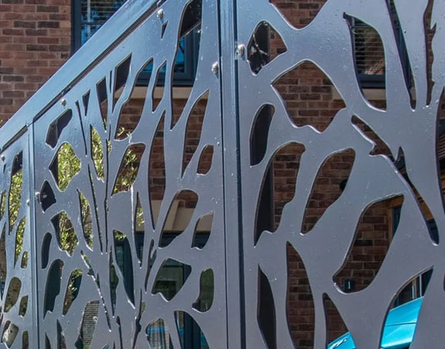 Close-up of a laser-cut steel gate panel with a leaf pattern