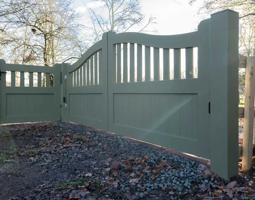 Sage green swing gates with a curved spindle top