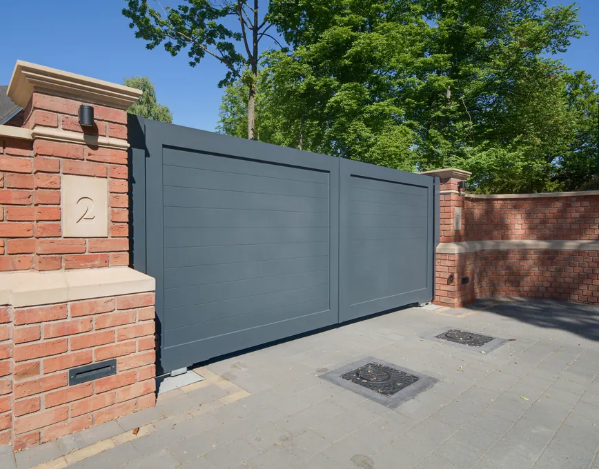 Grey aluminium driveway gates between brick piers, Solihull