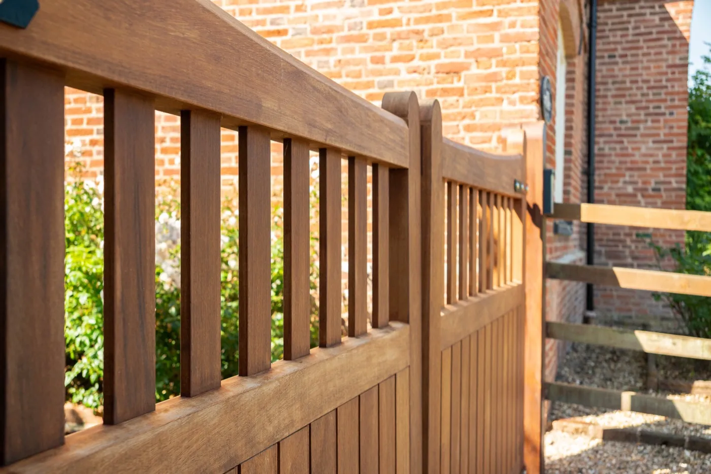 Railed top and boarded timber gate detail against brick, Hanbury
