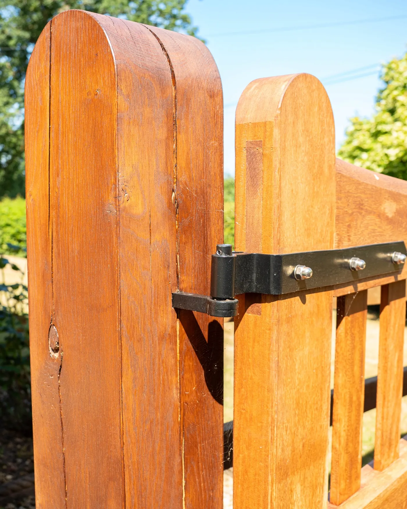 Curved timber gate tops with a black strap hinge, Hanbury