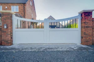 Pair of light grey swing driveway gates with a railed top between red brick piers, Droitwich Spa