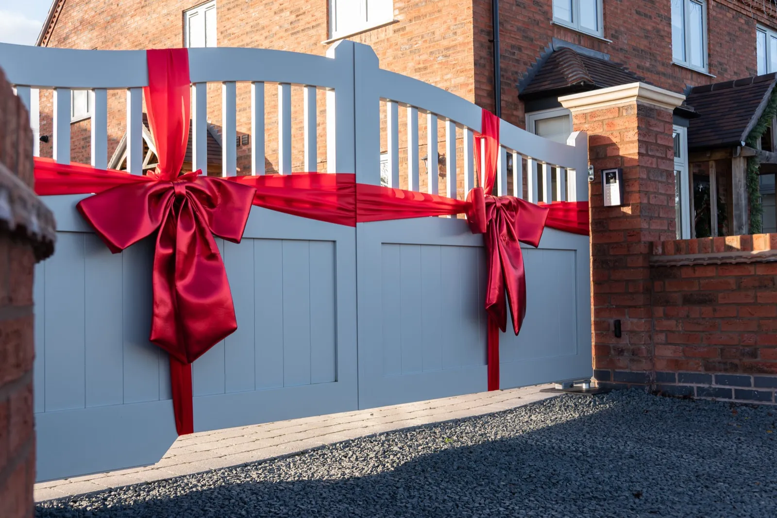 Grey spindle-top swing gates tied with a red ribbon, Droitwich Spa