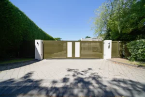 Olive green slatted swing gates with stone-effect panels between white rendered piers, Little Aston