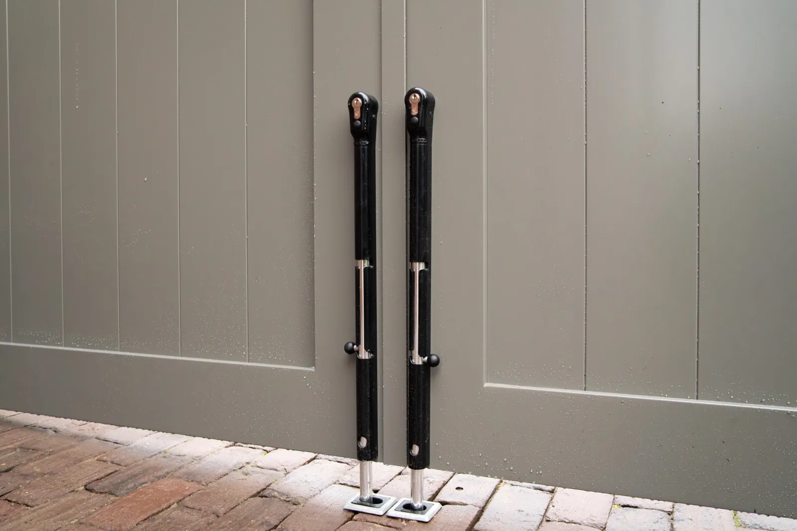 Drop bolts holding a pair of warm grey gates closed