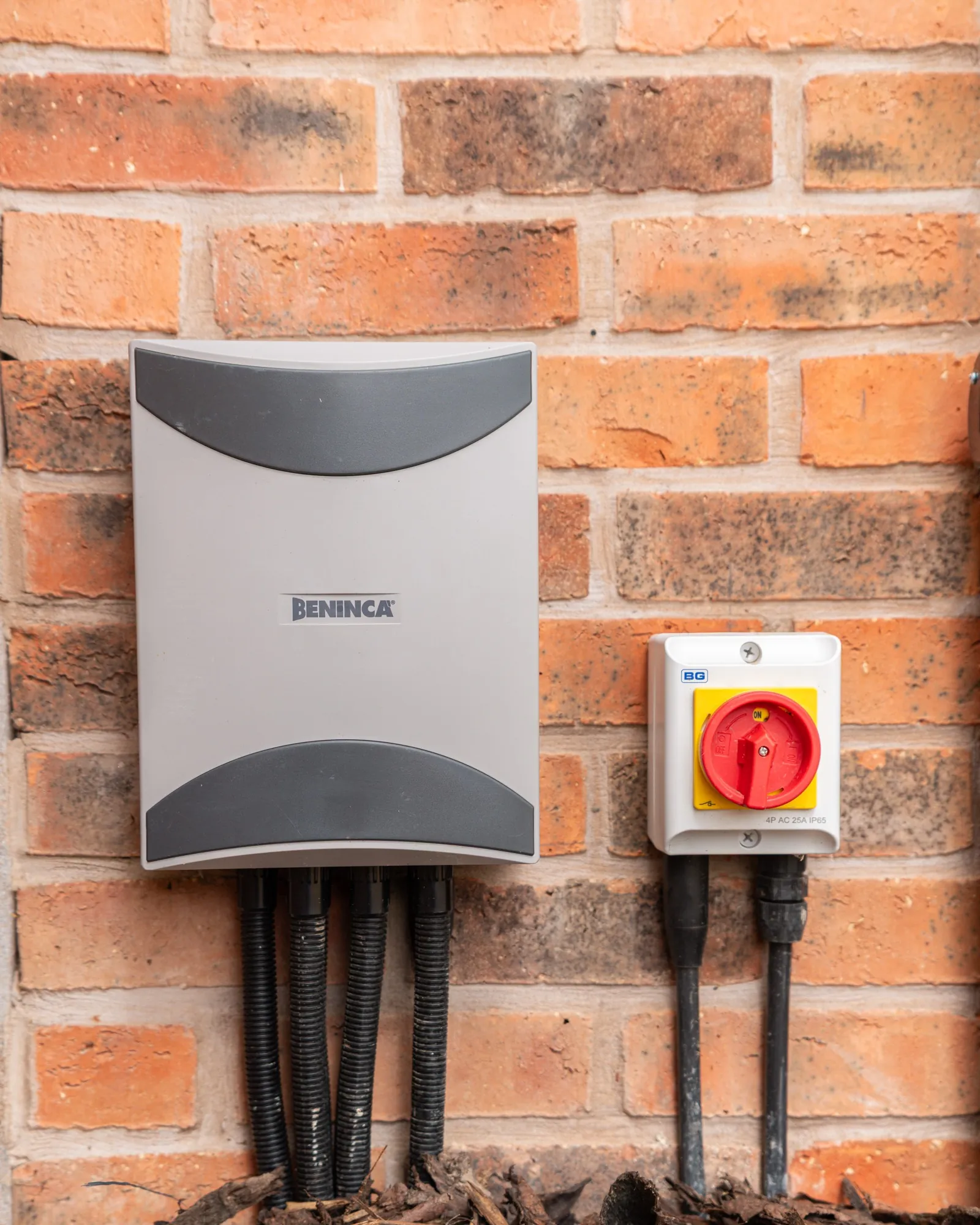 Beninca gate control box and isolator switch on a brick wall
